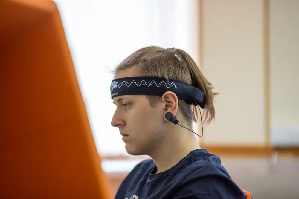 A participant wearing an EEG headband while concentrating on a task.