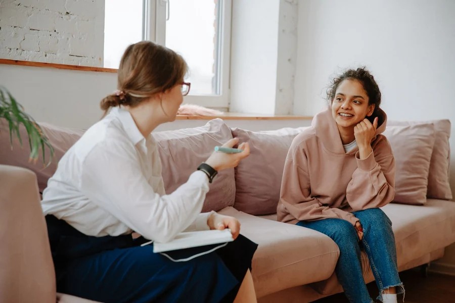 Two women having a thoughtful conversation in a counseling setting.