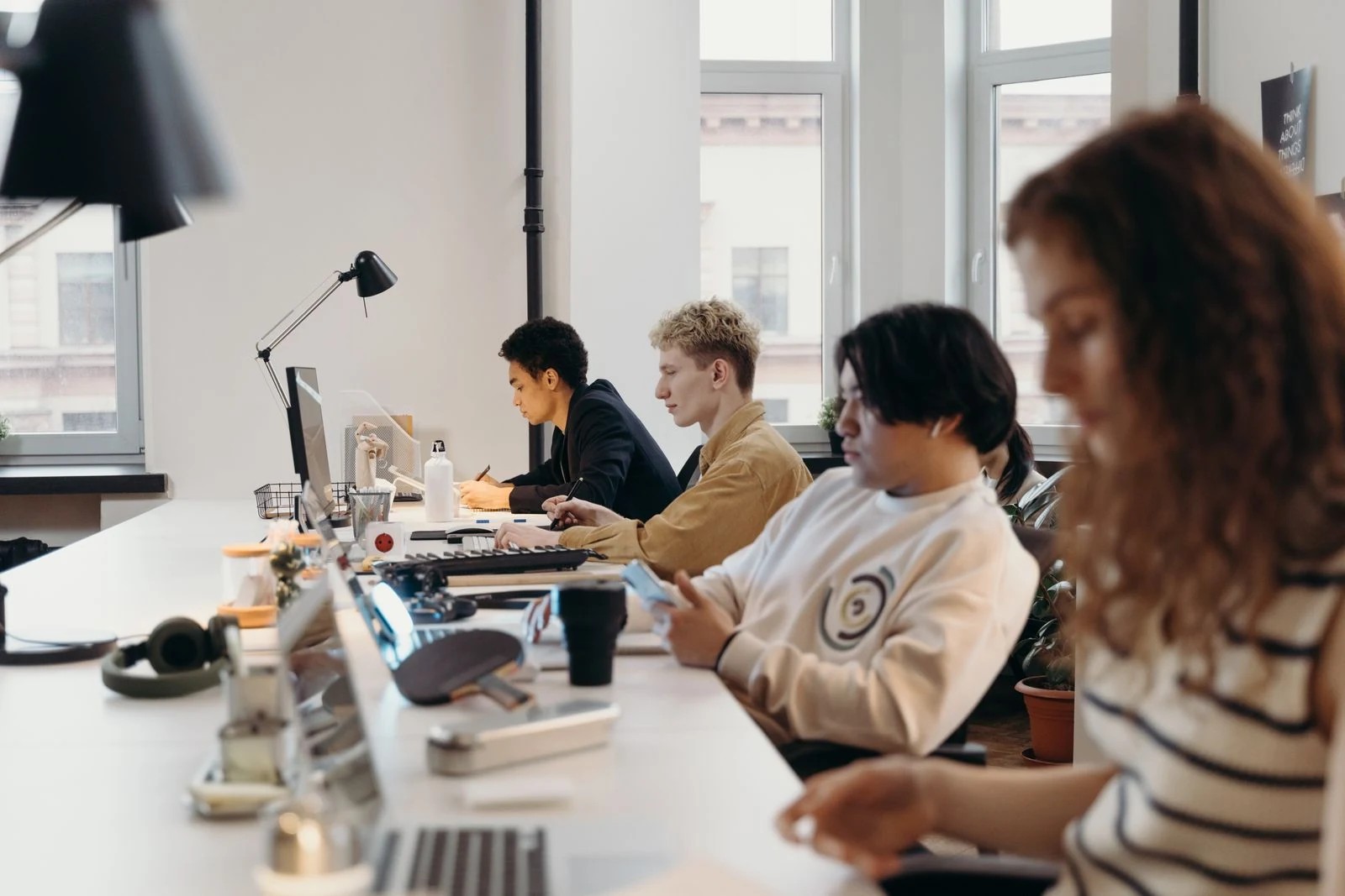 Colleagues working at a shared desk in a naturally lit office.
